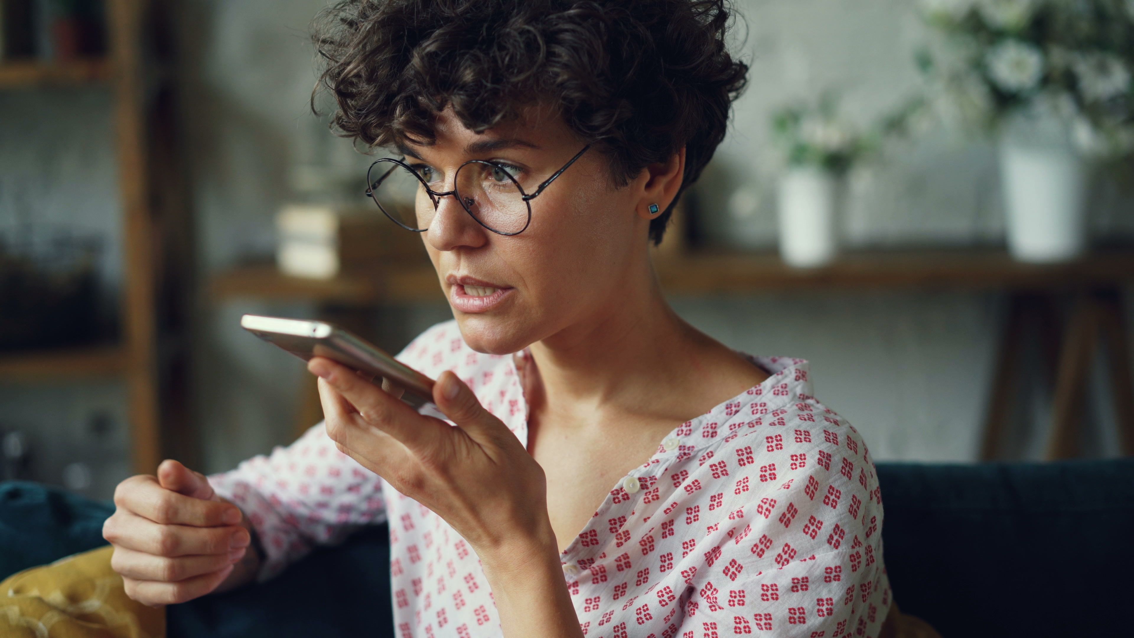 A woman speaking into her phone at home
